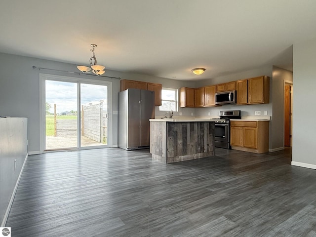 2082 Dusty Trl, Kingsley, MI 49649 - kitchen with appliances with stainless steel finishes, a chandelier, light countertops, dark wood-style floors, and pendant lighting