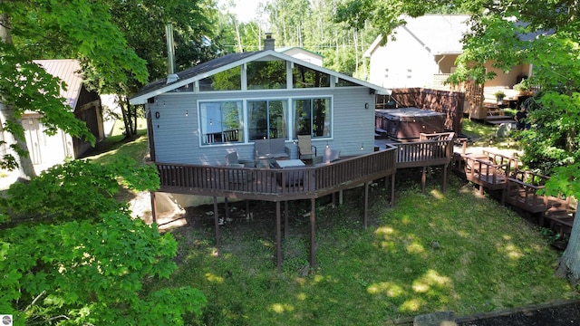7851 White Birch Dr, Farwell, MI 48622 - rear view of property featuring a hot tub, a deck, a chimney, and a yard