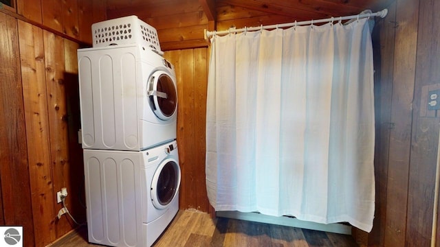 7851 White Birch Dr, Farwell, MI 48622 - washroom with stacked washing machine and dryer, wooden walls, and wood finished floors