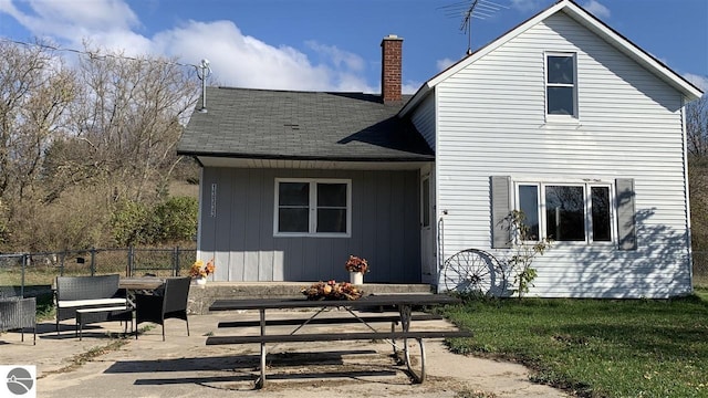 13333 S Coleman Rd, Empire, MI 49630 - back of property with a chimney, a patio, a shingled roof, and board and batten siding