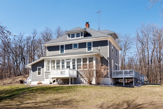 back of property featuring a yard and a wooden deck