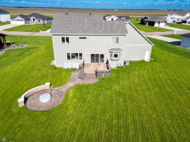 rear view of property featuring a garage and a lawn