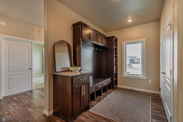 mudroom featuring a textured ceiling and dark wood-type flooring