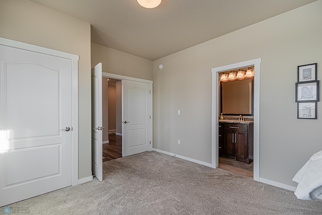 unfurnished bedroom with sink, connected bathroom, and light colored carpet