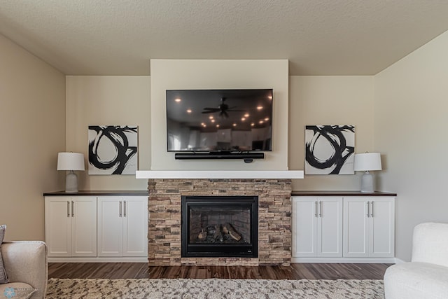 living room featuring a textured ceiling, a fireplace, and dark wood-type flooring