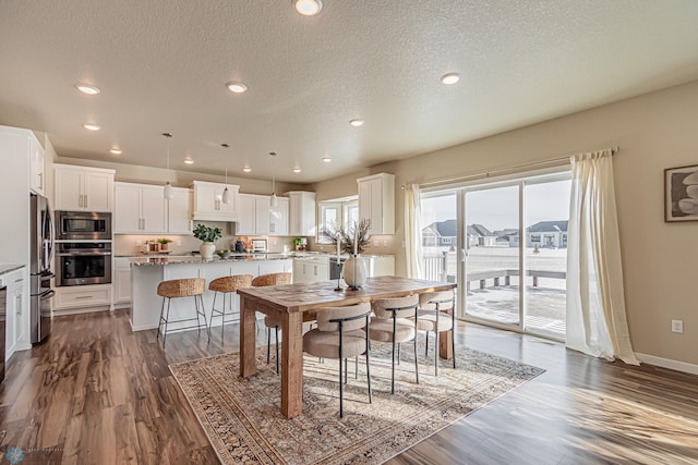 dining area featuring dark hardwood / wood-style flooring and a textured ceiling