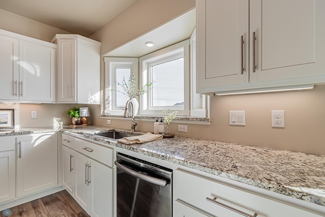 kitchen with dishwasher, light stone countertops, wood-type flooring, white cabinets, and sink