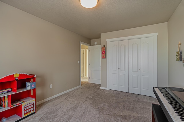 interior space featuring a closet, a textured ceiling, and carpet flooring