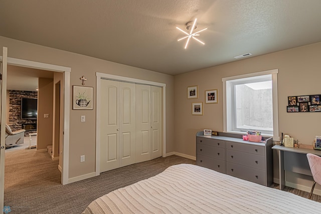 bedroom featuring a textured ceiling, a closet, and dark carpet