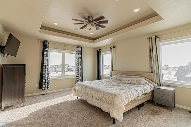 bedroom featuring ceiling fan, a raised ceiling, and carpet flooring