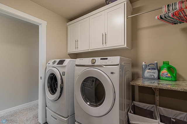 laundry room with separate washer and dryer, light carpet, and cabinets