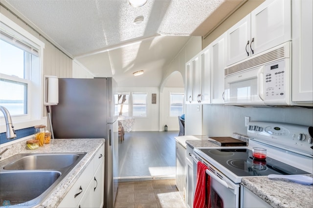 kitchen featuring white cabinets, a textured ceiling, white appliances, and sink