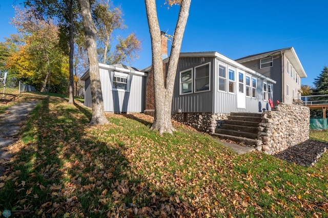 rear view of house featuring a storage unit