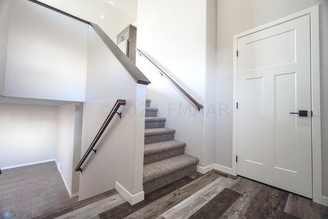 stairway with dark hardwood / wood-style floors