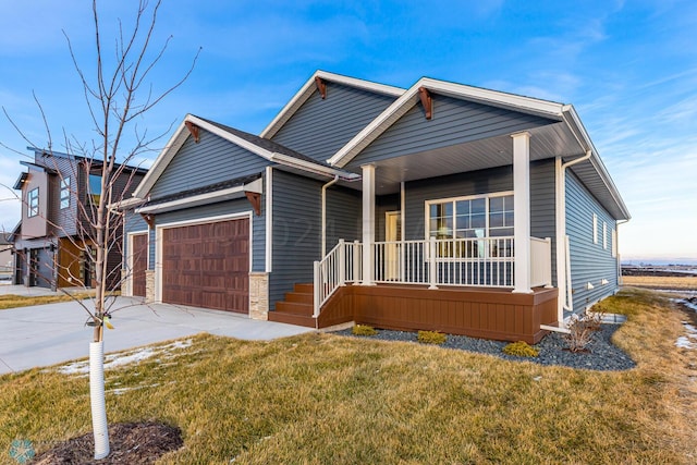 view of front of house with a porch, a garage, and a front yard