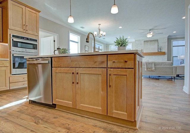 kitchen with appliances with stainless steel finishes, light hardwood / wood-style flooring, ceiling fan with notable chandelier, pendant lighting, and ornamental molding