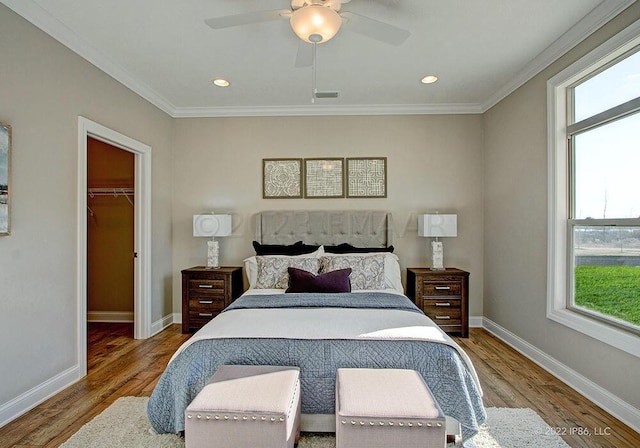 bedroom featuring hardwood / wood-style flooring, a closet, ceiling fan, and a spacious closet