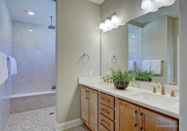 bathroom featuring dual sinks, tile floors, a textured ceiling, and large vanity