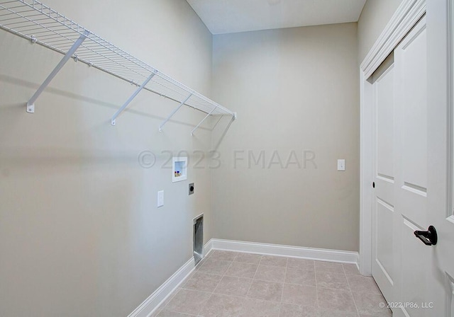 washroom with hookup for an electric dryer, light tile floors, and washer hookup