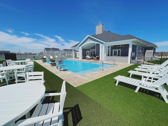 view of swimming pool featuring a patio and a yard