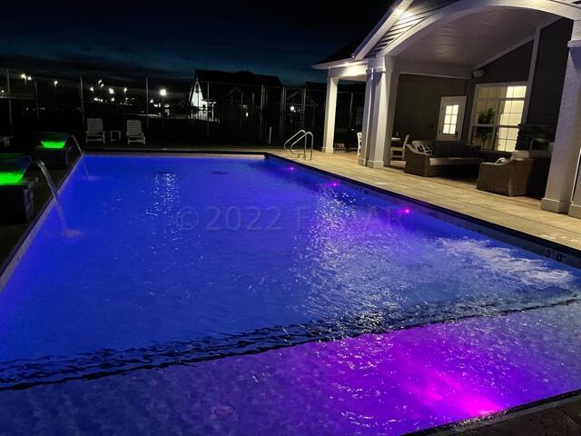 pool at night with outdoor lounge area