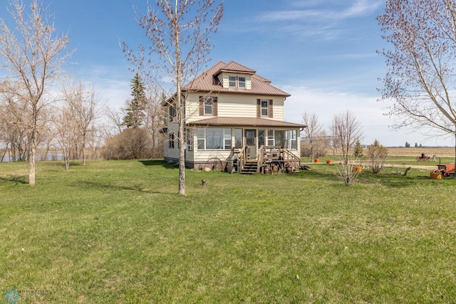 rear view of property with a deck and a yard