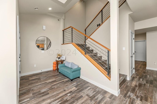 stairs featuring high vaulted ceiling and dark wood-type flooring