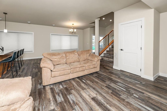 living room featuring an inviting chandelier and dark hardwood / wood-style floors