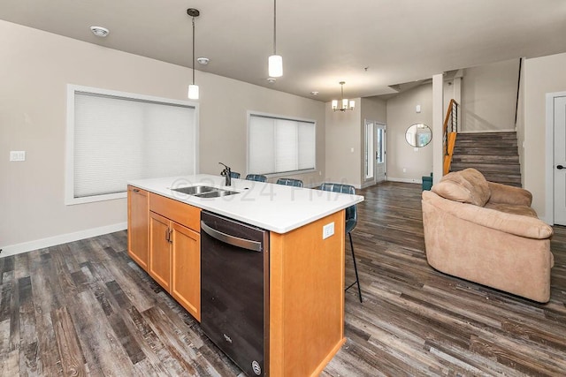 kitchen with black dishwasher, dark hardwood / wood-style floors, a chandelier, and a kitchen island with sink