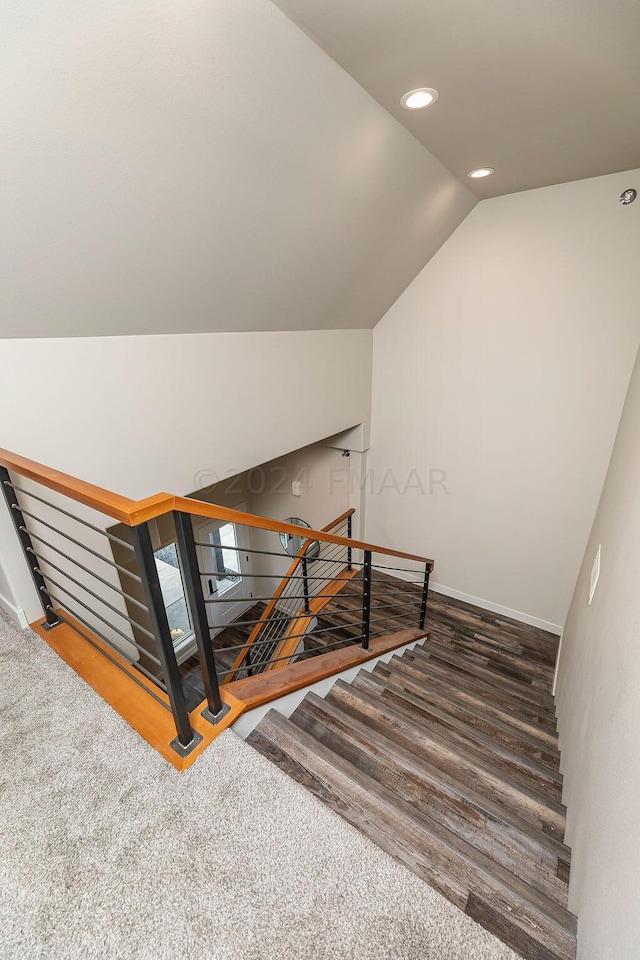 staircase with vaulted ceiling and dark hardwood / wood-style floors