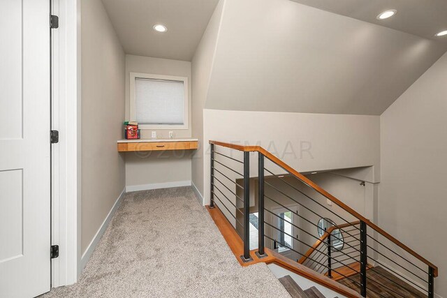 hall featuring light colored carpet and vaulted ceiling