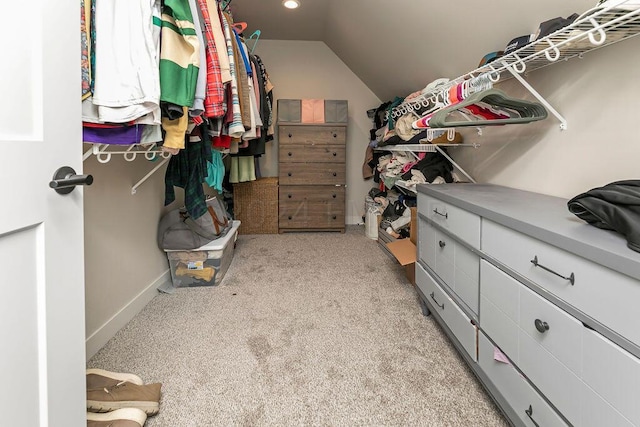 spacious closet with lofted ceiling and light carpet