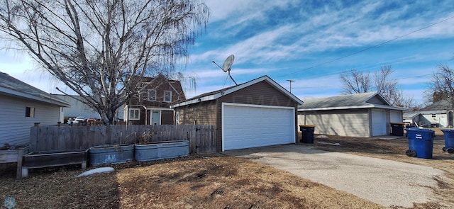 view of side of home featuring a garage and an outbuilding