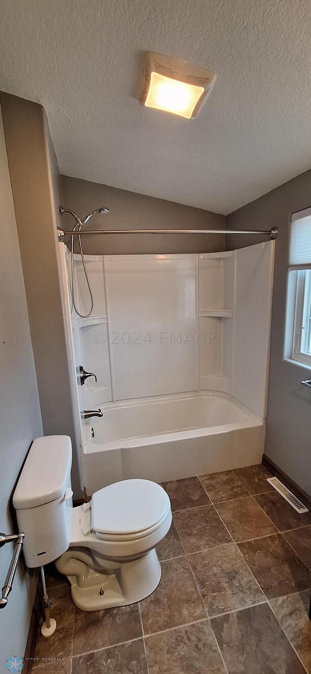 bathroom with tile patterned floors, bathing tub / shower combination, and toilet