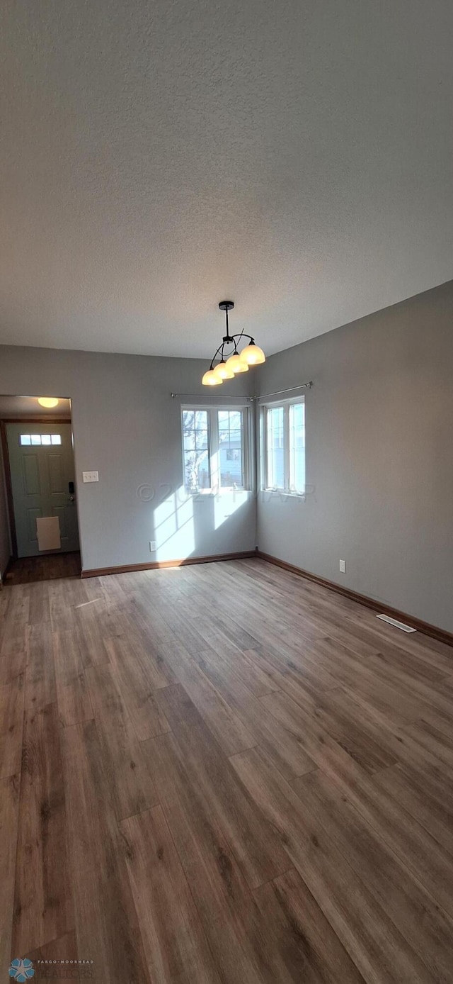 spare room featuring a textured ceiling and hardwood / wood-style flooring