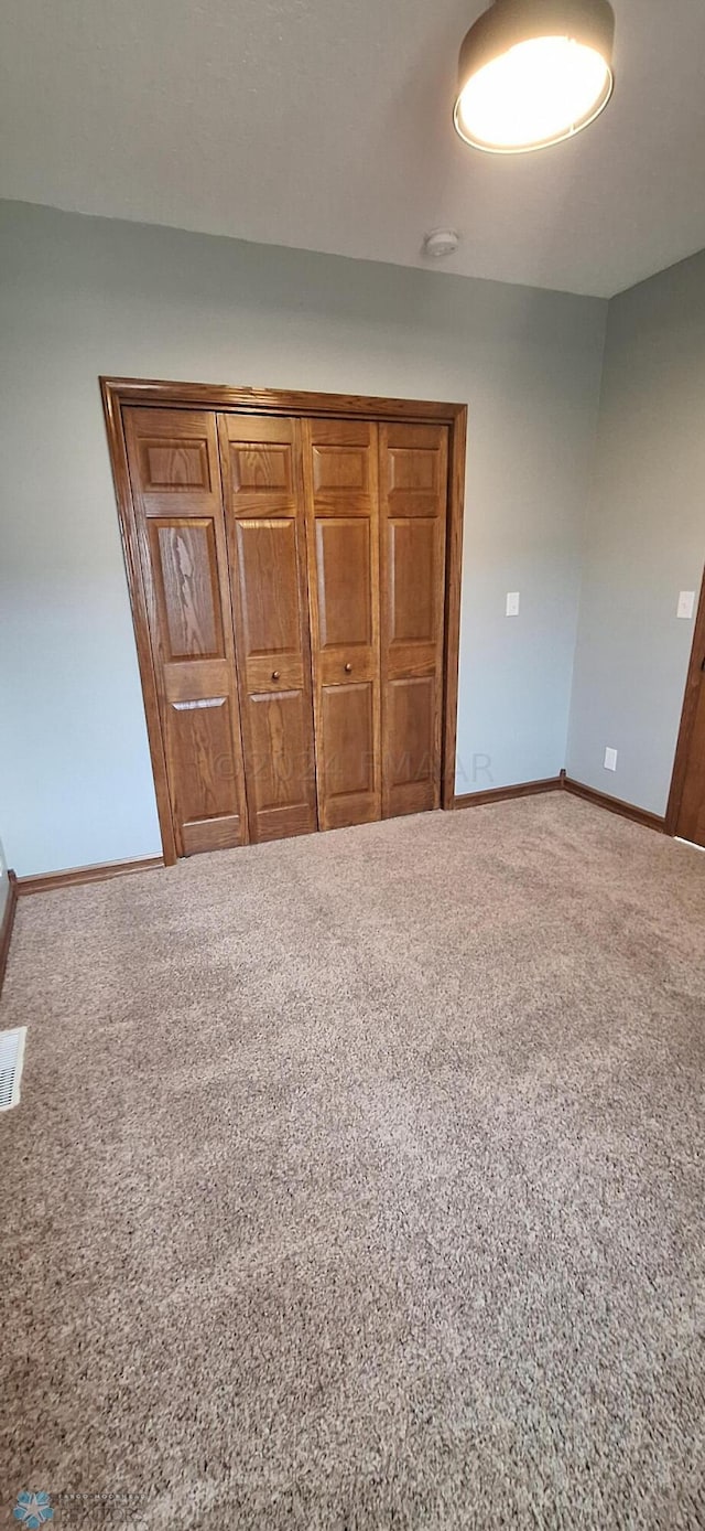 unfurnished bedroom featuring a closet and carpet flooring