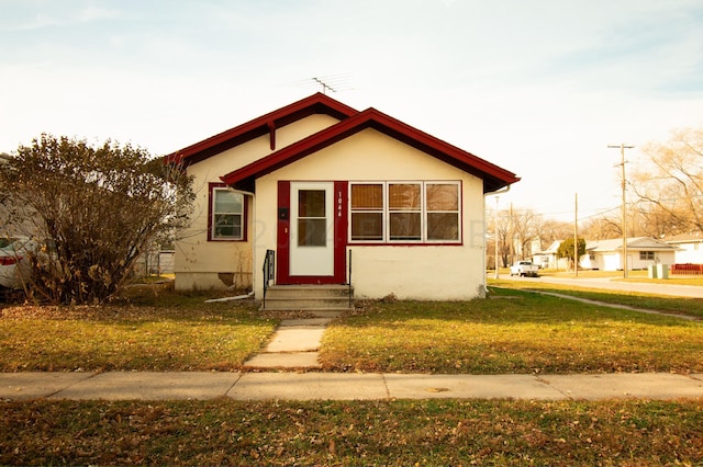 bungalow-style home with a front yard