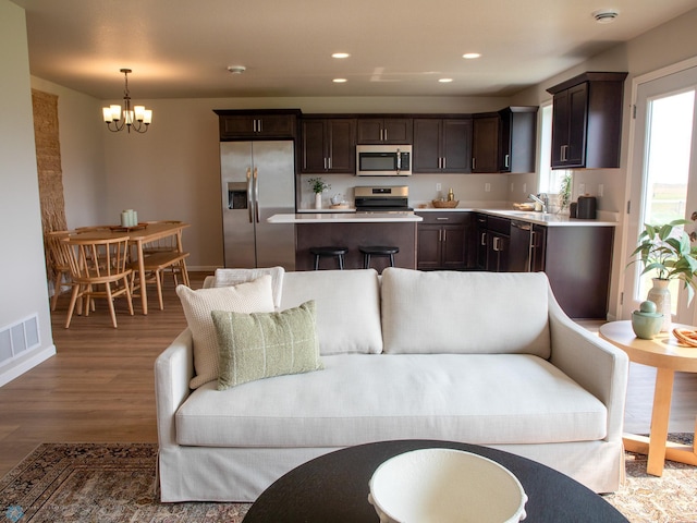 living room featuring a notable chandelier, hardwood / wood-style floors, and sink