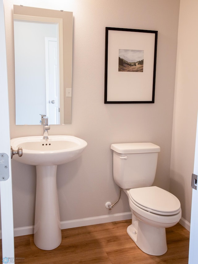 bathroom featuring wood-type flooring and toilet