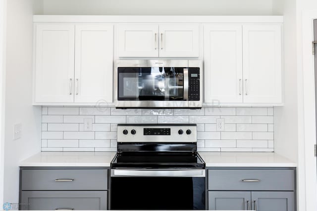 kitchen featuring white cabinets, tasteful backsplash, stainless steel appliances, and gray cabinets