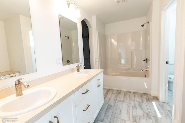 full bathroom featuring hardwood / wood-style floors, shower / tub combination, toilet, and double sink vanity