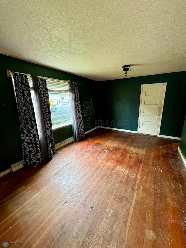 spare room with hardwood / wood-style flooring and a textured ceiling