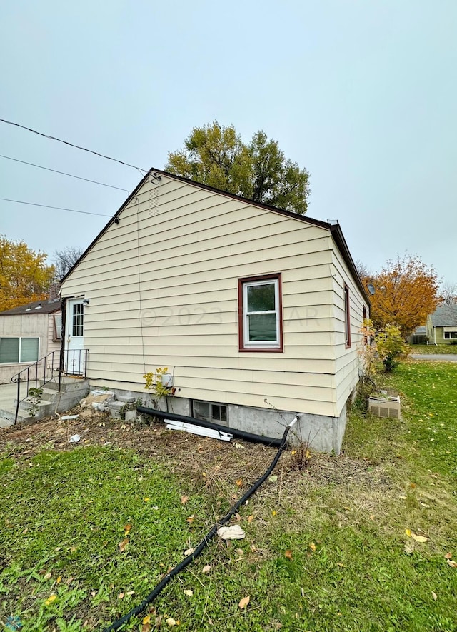 view of side of home with a lawn