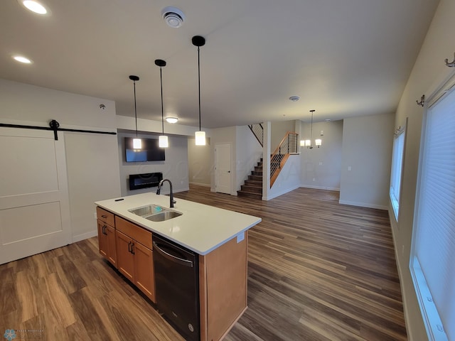 kitchen featuring decorative light fixtures, a barn door, dishwasher, dark wood-type flooring, and sink