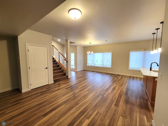 empty room with an inviting chandelier and dark hardwood / wood-style floors