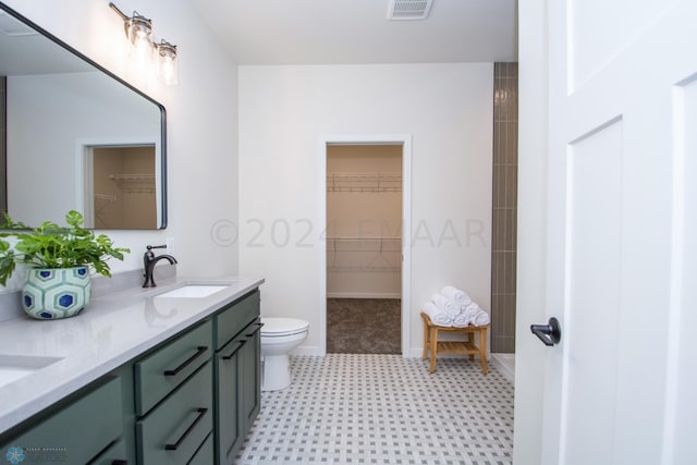 bathroom with double sink vanity, toilet, and tile flooring