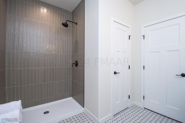 bathroom with tile flooring and a tile shower