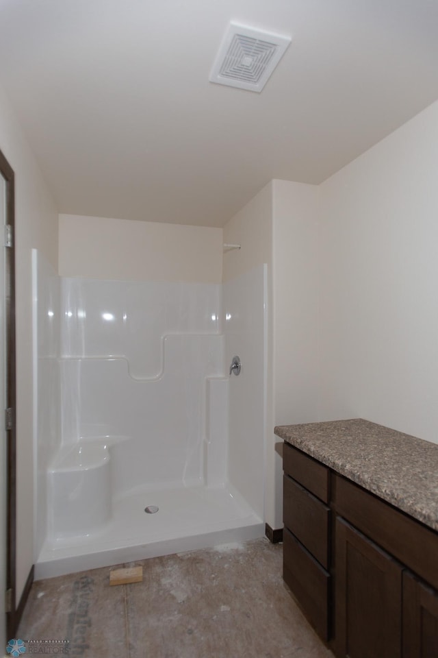 bathroom featuring a shower and vanity