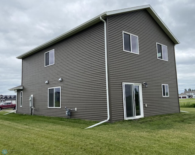 rear view of property featuring a lawn