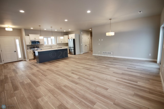 kitchen with pendant lighting, light hardwood / wood-style floors, and stainless steel appliances